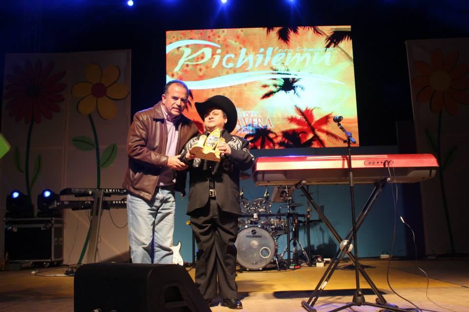 Hugo Macaya, ganador de un concurso de talentos, recibe un reconocimiento del Alcalde Córdova tras participar en el show de clausura de la Fiesta de la Primavera.