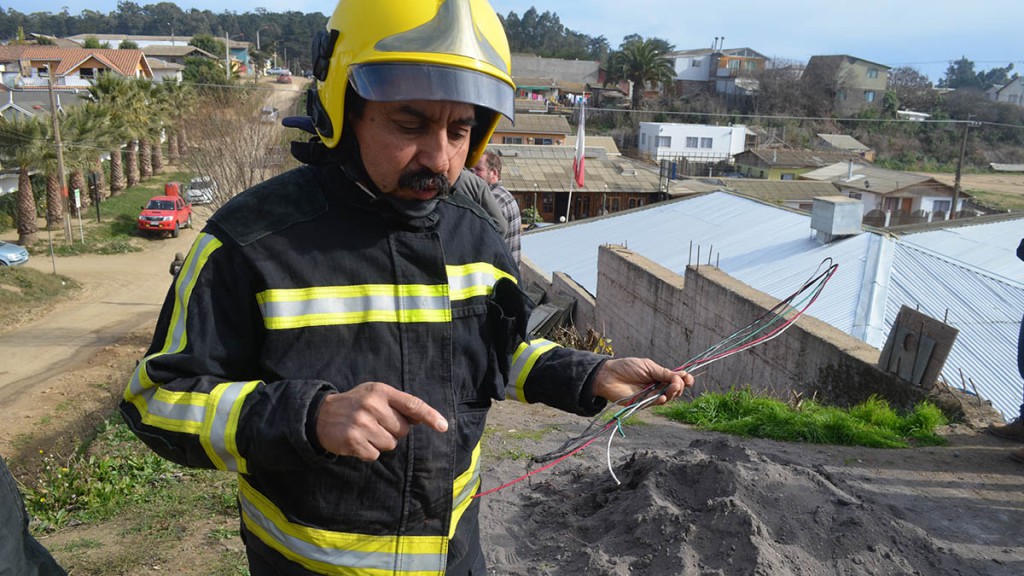 El bombero encargado de la unidad técnica, Luis González, Bombero encargado de la unidad técnica, muestra los cables eléctricos quemados, que al recalentarse se juntaron y produjeron el humo.