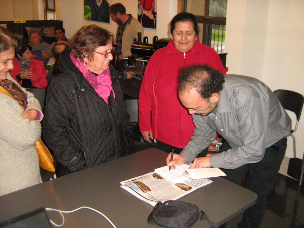 El autor, Víctor León, autografía un libro para las asistentes.